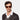 A man wearing Mastro Eco Dark Havana sunglasses by TBD Eyewear red lenses, sustainable materials, and a timeless design handcrafted in Italy