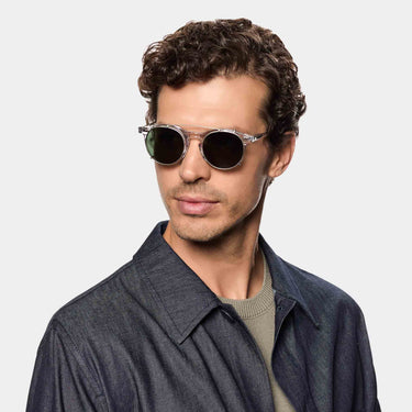 A smiling man wearing sunglasses pleat eco transparent silver bottle green sustainable tbd eyewear made in Italy