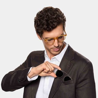 A man wearing Pleat sunglasses by TBD Eyewear Honey Gold bio-acetate frame with Bottle Green lenses, made in Italy