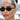 Close-up of Zoë Kravitz wearing black oval-shaped sunglasses