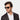 A man wearing sustainable Cran sunglasses by TBD Eyewear in Eco Black Gradient Grey made from bio-acetate and made in Italy