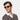 Smiling Man wearing TBD Eyewear's Raso Eco sunglasses in Champagne Bottle Green lenses with sustainable frame made in Italy