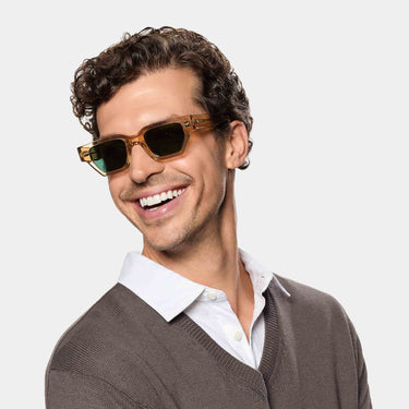Smiling Man wearing TBD Eyewear's Raso Eco sunglasses in Champagne Bottle Green lenses with sustainable frame made in Italy
