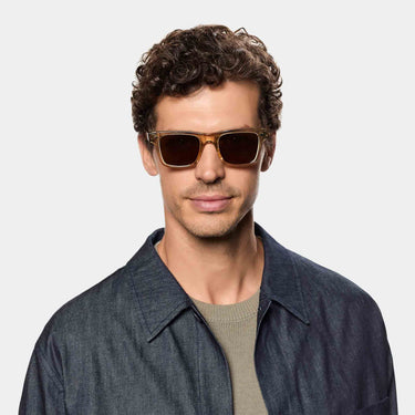 A man wearing sunglasses denim eco champagne tobacco sustainable tbd eyewear handcrafted in Italy