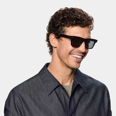 A smiling man wearing sunglasses denim eco black gradient grey sustainable tbd eyewear front handcrafted in Italy