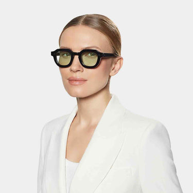 Woman wearing the Juta model by TBD Eyewear in Eco Black with Light Green lenses sustainable choice made in italy